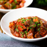 Filipino beef mechado stew with carrots and potatoes in a tomato sauce.