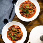 Overhead Filipino beef mechado stew with carrots and potatoes in a tomato sauce.