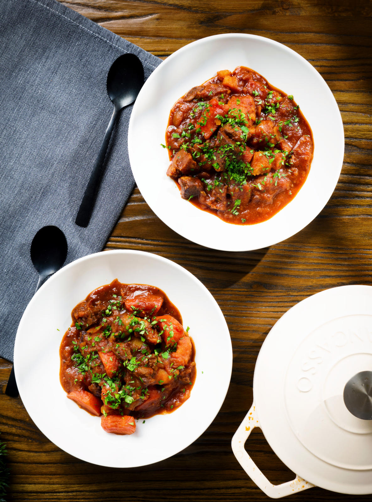 Overhead Filipino beef mechado stew with carrots and potatoes in a tomato sauce.