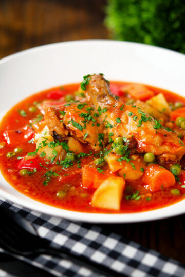 Filipino chicken afritada stew with potatoes, carrots, peppers and peas.