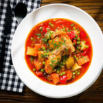 Filipino chicken afritada stew with potatoes, carrots, peppers, raisins and peas.