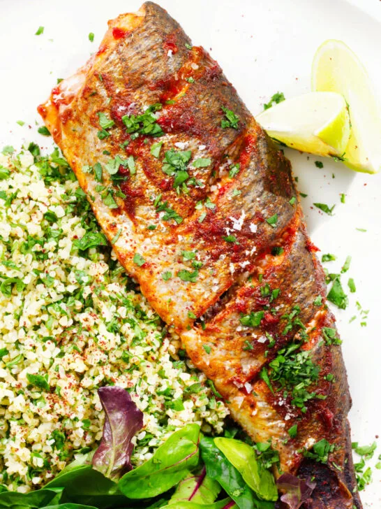 Overhead close-up harissa baked/roasted rainbow trout with herbed bulgur wheat.