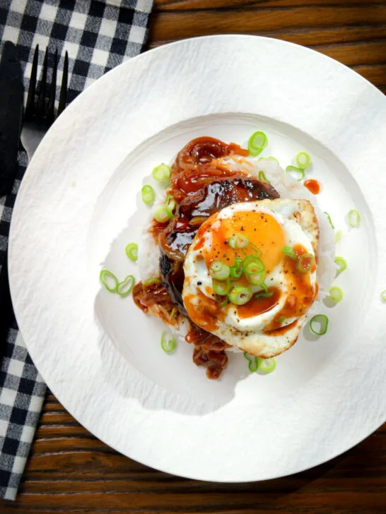 Overhead Hawaiian loco moco: beef patty, white rice, gravy and a fried egg.