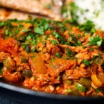 Close-up Indian-influenced canned tuna curry served with rice and chapatis.