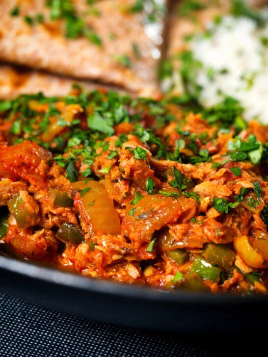 Close-up Indian-influenced canned tuna curry served with rice and chapatis.