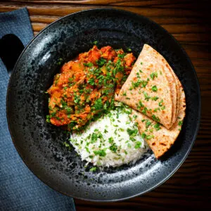 Indian-influenced canned tuna curry served with steamed rice and chapatis garnished with coriander.