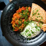 Overhead Indian-influenced canned tuna curry served with rice and chapatis.