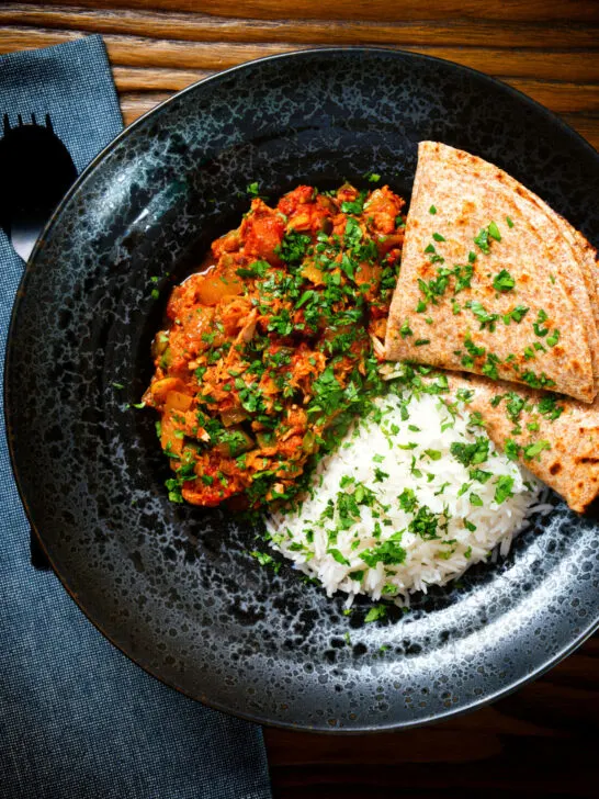 Overhead Indian-influenced canned tuna curry served with rice and chapatis.