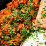 Close-up overhead Indian-influenced canned tuna curry served with rice and chapatis.