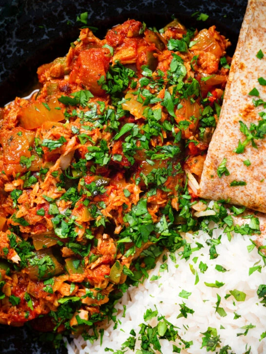 Close-up overhead Indian-influenced canned tuna curry served with rice and chapatis.