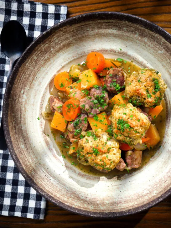 Overhead minted lamb stew with dumplings, swede and carrots.