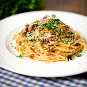 Pasta (spaghetti) foriana with walnuts, pine nuts and raisins garnished with parsley.