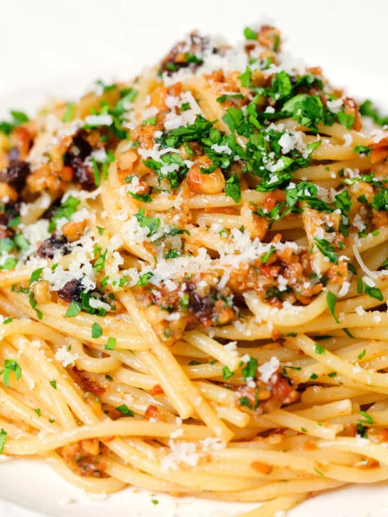 Close-up pasta foriana with walnuts, pine nuts and raisins garnished with parsley.