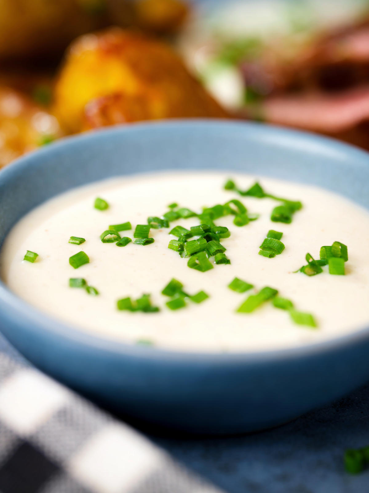 Overhead close-up French soubise (white onion sauce) with snipped chives.