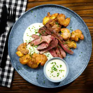 French soubise (onion sauce) with skirt steak and crushed potatoes.