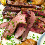 Overhead close-up marinated steak bavette (Flank Steak) served with soubise and crushed potatoes.