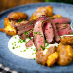 Marinated steak bavette (Flank Steak) served with soubise and crushed potatoes.