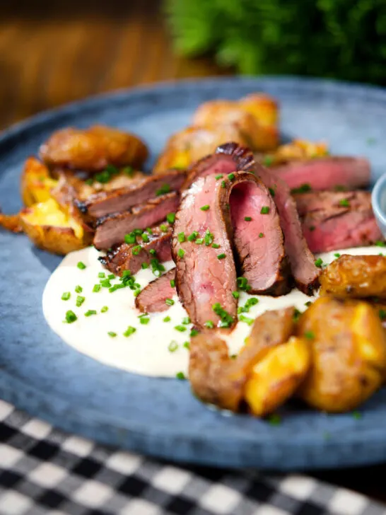 Marinated steak bavette (Flank Steak) served with soubise and crushed potatoes.