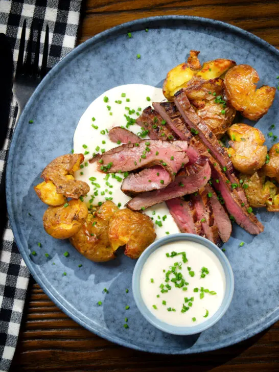 Overhead marinated steak bavette (Flank Steak) served with soubise and crushed potatoes.