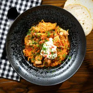 Hungarian sz&eacute;kelyk&aacute;poszta: pork belly and sauerkraut stew served with sour cream.