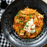 Overhead Hungarian sz&eacute;kelyk&aacute;poszta: pork belly and sauerkraut stew served with sour cream and bread.
