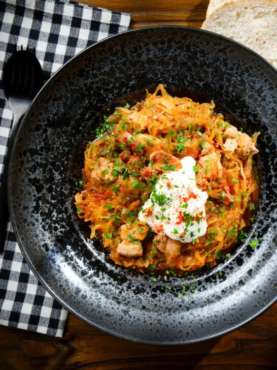Overhead Hungarian sz&eacute;kelyk&aacute;poszta: pork belly and sauerkraut stew served with sour cream and bread.