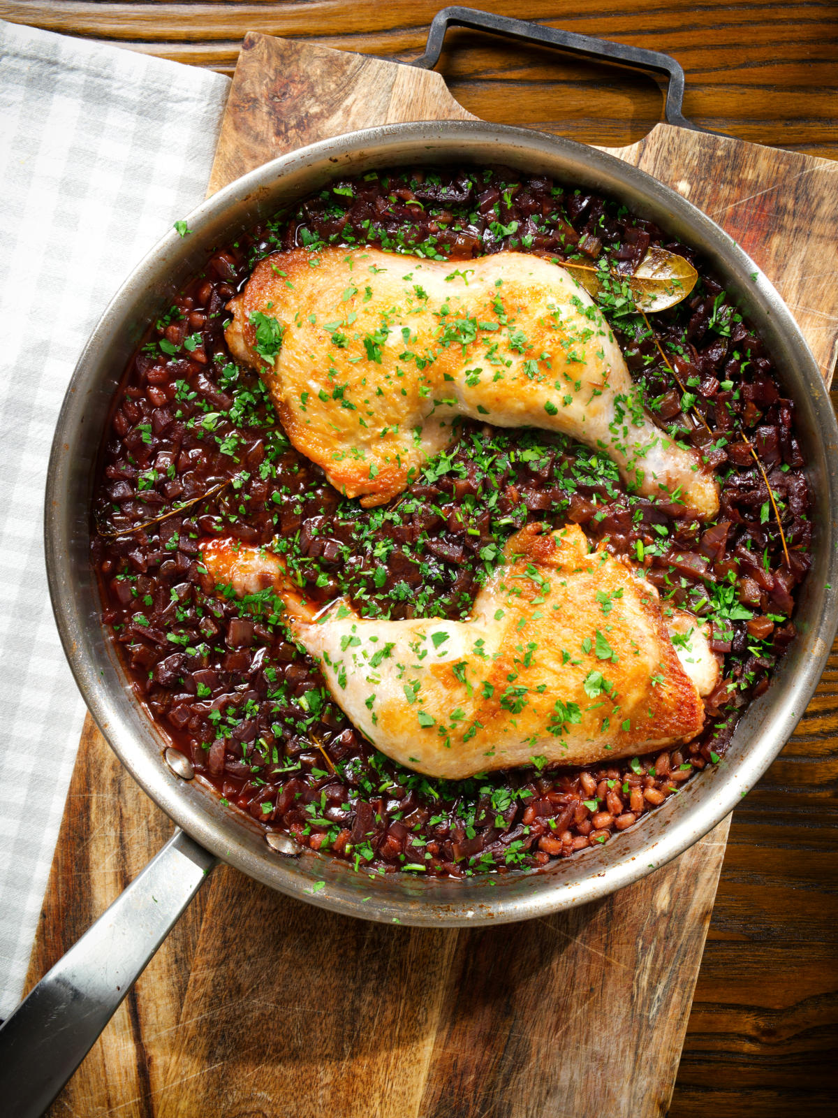 Overhead close-up chicken leg and pearl barley stew in its cooking pan.