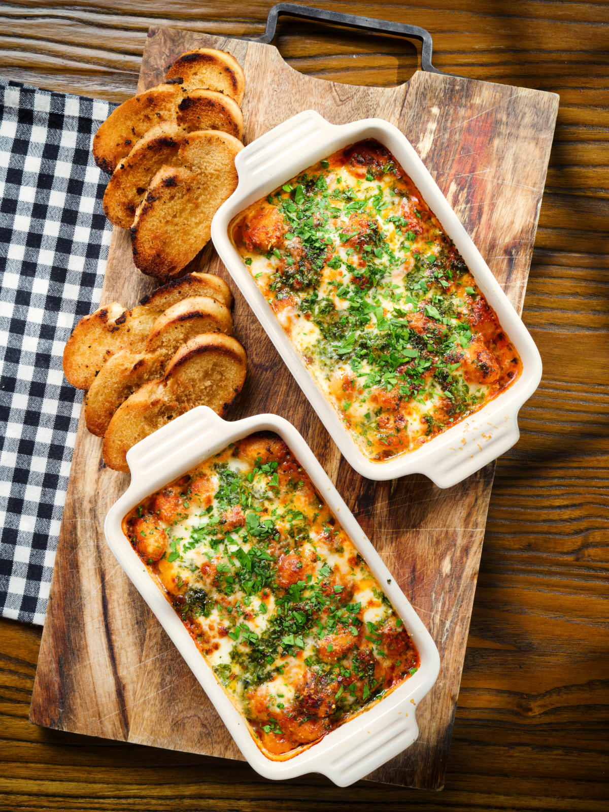 Overhead individual Baked gnocchi alla sorrentina in a tomato and mozzarella sauce.