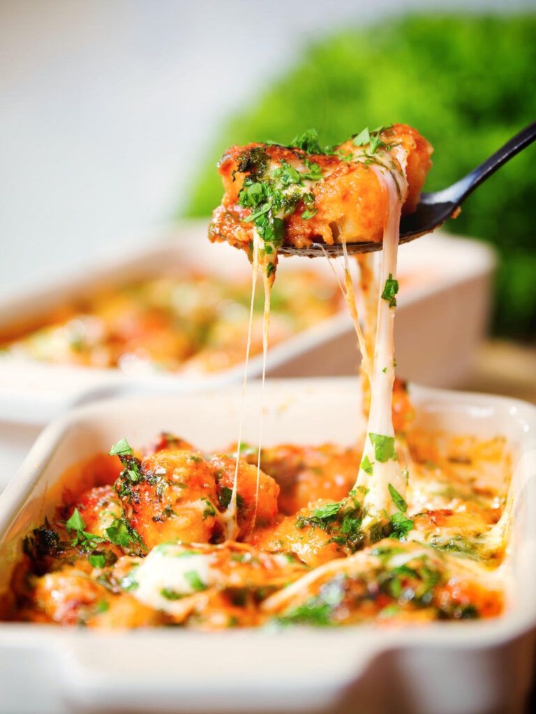 Baked gnocchi alla sorrentina being picked up with a spoon.