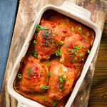 Overhead baked Thai red curry chicken thighs in a baking dish.