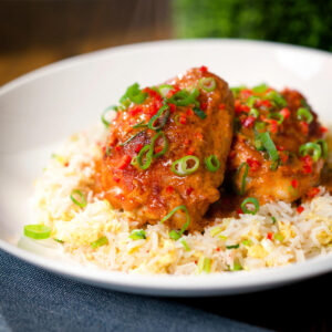 Roasted Thai red curry chicken thighs served with egg fried rice and spring onions.