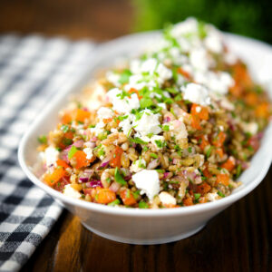 Warm freekeh salad with feta cheese, peppers and tomatoes.