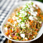 Warm freekeh salad with feta cheese, peppers, tomatoes and parsley.