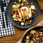 Overhead ham, black pudding and potato hash served with a fried egg.
