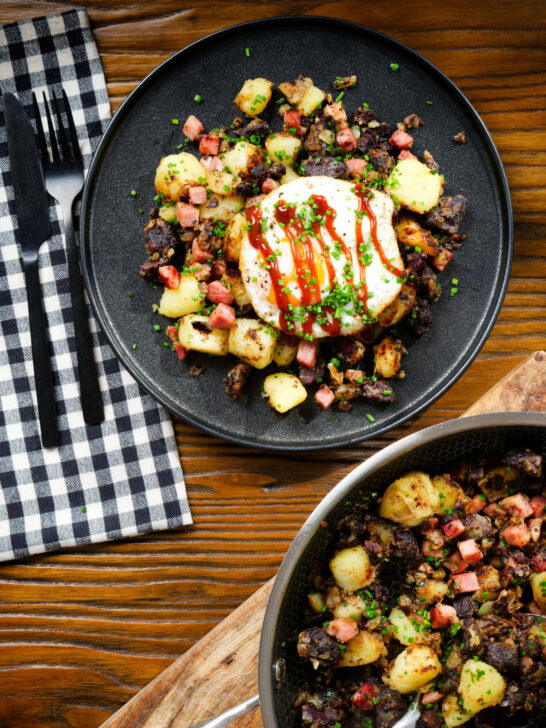 Overhead ham, black pudding and potato hash served with a fried egg.