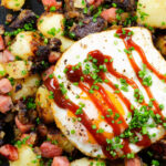 Close-up overhead ham, black pudding and potato hash served with a fried egg.