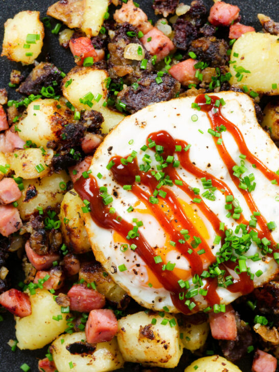 Close-up overhead ham, black pudding and potato hash served with a fried egg.