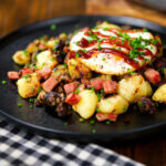 Ham and black pudding hash served with a fried egg and brown sauce.