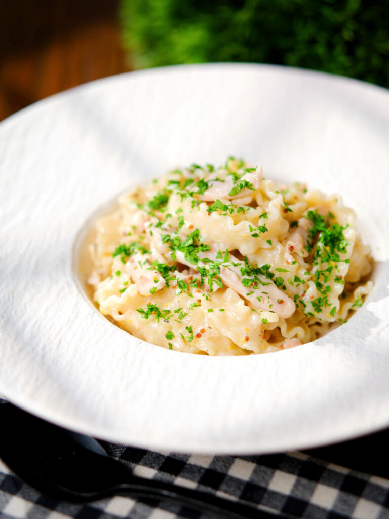 Honey and mustard chicken pasta (malfadine) with chopped parsley.