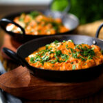 Creamy Kashmiri-style chicken curry served in a kadai with coriander.