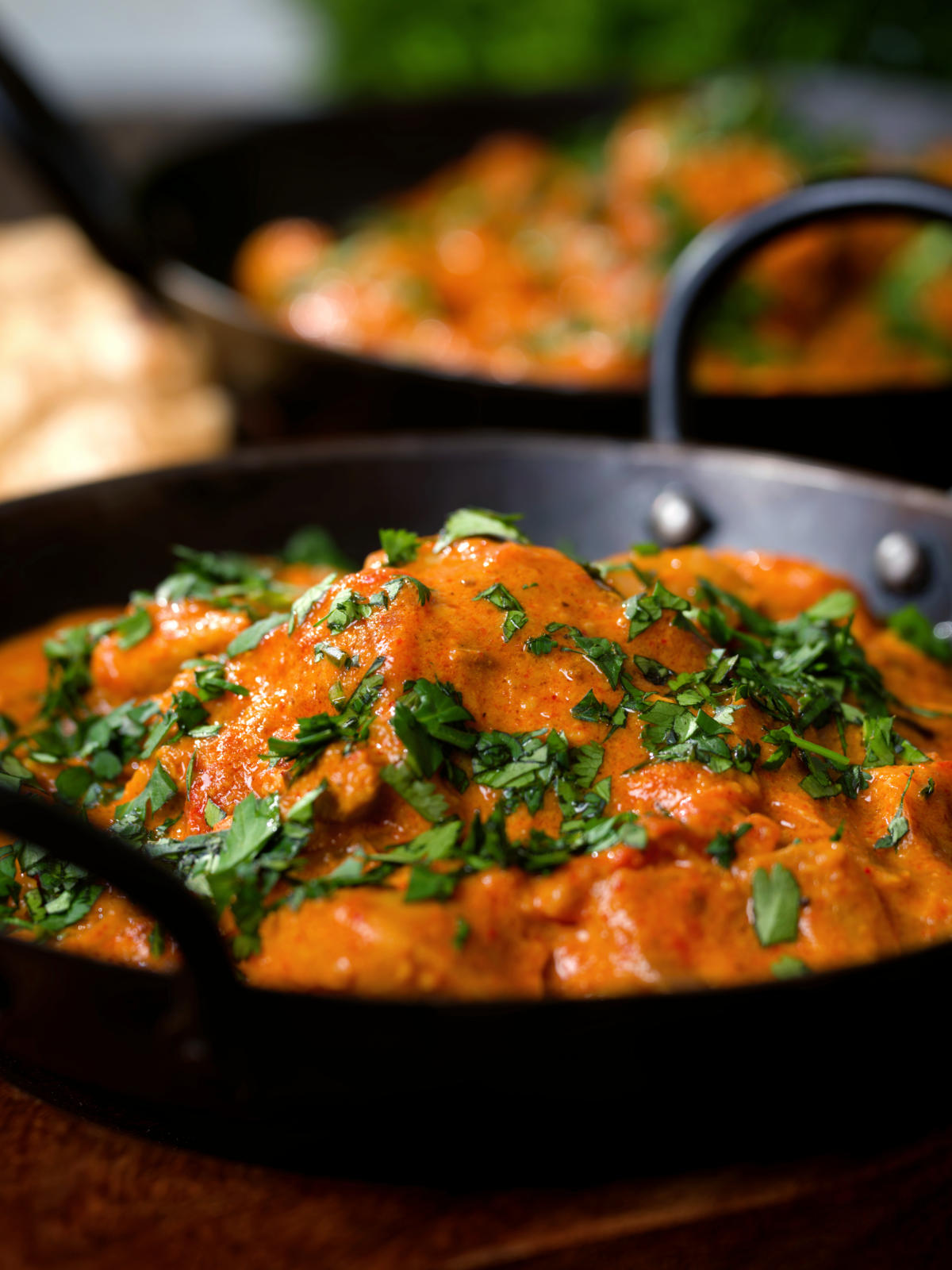 Close-up Kashmiri-style chicken curry served in a kadai with coriander.
