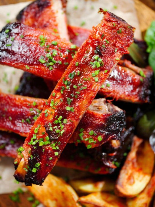 Overhead close-up Korean gochujang glazed pork ribs served with potato wedges.