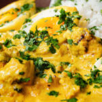 Close-up kuku paka: African chicken curry with boiled eggs served with white rice.