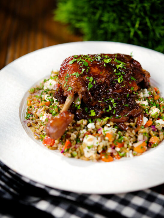 Baked pomegranate molasses duck leg with onions, served with a feta freekeh salad.