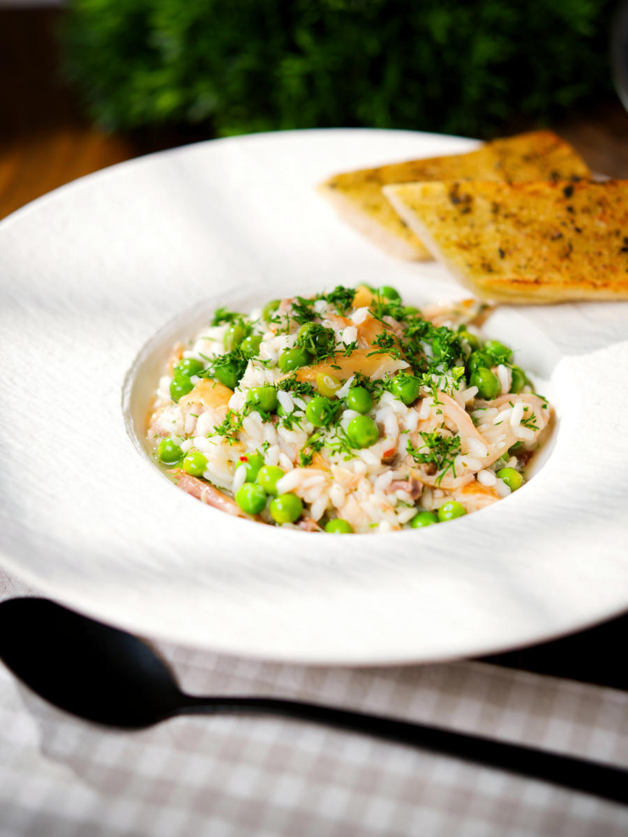 Smoked mackerel risotto with peas and dill served with garlic bread.