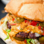 Close-up Mexican beef burger with salsa fresca, chipotle mayonnaise.