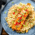 Overhead sweet chilli sauce baked salmon with egg fried rice, fresh chilli and spring onions.
