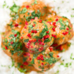 Overhead close-up Thai red curry chicken meatballs served with white rice.