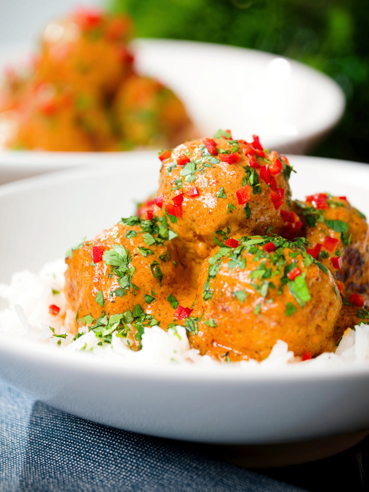 Close-up Thai red curry chicken meatballs served with white rice.