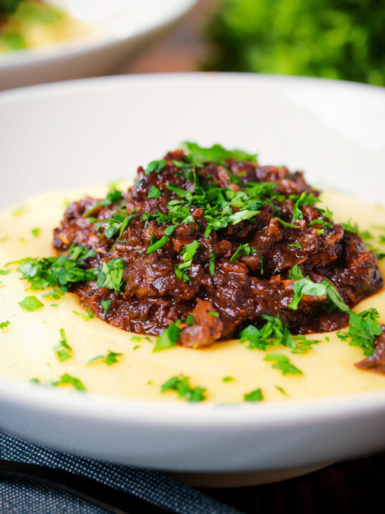 Close-up vegan mushroom ragu sauce served with creamy polenta.